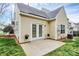 Cozy back patio featuring double doors, potted plants, and a verdant backyard at 11539 Delores Ferguson Ln, Charlotte, NC 28277