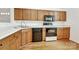 This kitchen has a stainless steel sink, black appliances, wooden cabinets, and hardwood floors at 11539 Delores Ferguson Ln, Charlotte, NC 28277