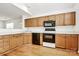 The kitchen features a stainless steel sink, black appliances, wooden cabinets, and hardwood floors at 11539 Delores Ferguson Ln, Charlotte, NC 28277