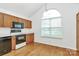 Bright kitchen featuring wooden cabinets, modern appliances, and an arched window for natural light at 11539 Delores Ferguson Ln, Charlotte, NC 28277