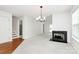 Bright living room features a fireplace, modern light fixture, and access to the staircase and back patio at 11539 Delores Ferguson Ln, Charlotte, NC 28277