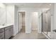 Bright bathroom featuring gray cabinets, double vanity and a glass shower at 121 Vaquaro Dr, Mooresville, NC 28115