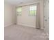 Well-lit room with two windows adorned with floor-length curtains and neutral carpet at 1218 Green Oaks Ln # E, Charlotte, NC 28205