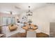 Bright dining area features a modern chandelier, adjacent to the living room with bright window doors at 1218 Green Oaks Ln # E, Charlotte, NC 28205