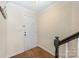 Inviting entryway with hardwood floors, coat hooks, and a white front door with a brick accent wall at 1218 Green Oaks Ln # E, Charlotte, NC 28205