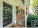 Charming home featuring a black front door, brick facade, and a cozy covered porch, all complemented by lush greenery at 1218 Green Oaks Ln # E, Charlotte, NC 28205