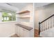 Open kitchen area includes open shelving, granite counters, and a staircase with railing at 1218 Green Oaks Ln # E, Charlotte, NC 28205