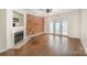 Spacious living room with hardwood floors, a brick accent wall, fireplace, and access to the outdoors at 1218 Green Oaks Ln # E, Charlotte, NC 28205