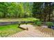 Serene backyard featuring a wooden deck, lush green lawn, and mature trees at 12531 Morning Creek Ln, Charlotte, NC 28214