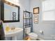 Powder room with a pedestal sink, toilet, and decorative wall art at 12531 Morning Creek Ln, Charlotte, NC 28214