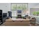 Open living room with a fireplace, large windows, and a comfortable seating arrangement at 12531 Morning Creek Ln, Charlotte, NC 28214