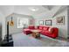 Comfortable living room with red sectional sofa, guitar, and neutral decor at 12531 Morning Creek Ln, Charlotte, NC 28214