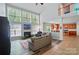 Bright living room featuring a fireplace, tall windows, and views to the kitchen area at 12531 Morning Creek Ln, Charlotte, NC 28214