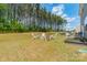Spacious backyard with Adirondack chairs around a fire pit, surrounded by lush trees and green grass at 127 Slip Shot Ln, Troutman, NC 28166