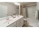 Bathroom with double vanity, framed floral art, and a shower-tub combination with a decorative curtain at 127 Slip Shot Ln, Troutman, NC 28166