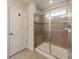 Modern bathroom with a glass-enclosed shower with a built-in bench and neutral ceramic tiling at 127 Slip Shot Ln, Troutman, NC 28166