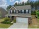 Charming brick and blue two-story home with a two-car garage and manicured front lawn at 127 Slip Shot Ln, Troutman, NC 28166