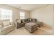 Cozy living room with comfortable sectional sofa, ottoman, and natural light from windows at 127 Slip Shot Ln, Troutman, NC 28166