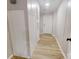 Hallway featuring light colored walls and wood floors leading to a white door at 1274 Oakbrook Ln, Denver, NC 28037