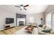 Cozy living room featuring a brick fireplace, ceiling fan, and light colored wood flooring at 1274 Oakbrook Ln, Denver, NC 28037