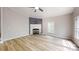 Inviting living room featuring light colored wood flooring, white brick fireplace and abundant natural light at 1274 Oakbrook Ln, Denver, NC 28037