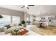 Open-concept living room with large windows, a ceiling fan, and views into the eat-in kitchen at 1274 Oakbrook Ln, Denver, NC 28037