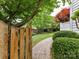 Charming backyard garden with stone pathway, a wooden fence, manicured shrubs, and mature trees at 135 Coronilla Rd, Mooresville, NC 28117