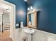 Stylish bathroom featuring a pedestal sink, framed mirror, and attractive blue walls at 135 Coronilla Rd, Mooresville, NC 28117