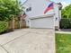 Home exterior features a two-car garage, a gray concrete driveway, and is decorated with American flags at 135 Coronilla Rd, Mooresville, NC 28117