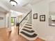 Bright and airy foyer with hardwood floors, staircase, and transom windows above the entryway door at 135 Coronilla Rd, Mooresville, NC 28117