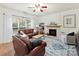 Inviting living room featuring a fireplace, large windows, and comfortable leather seating at 135 Coronilla Rd, Mooresville, NC 28117