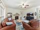 Cozy living room with fireplace, ceiling fan, leather couches, and TV at 135 Coronilla Rd, Mooresville, NC 28117