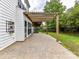 Back patio features a wooden pergola, stone paver floor, and access to the yard at 135 Coronilla Rd, Mooresville, NC 28117