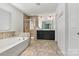 Bathroom with double vanity, soaking tub, and glass shower, tiled floor, plus natural light at 1617 Post Ct, Gastonia, NC 28054