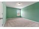 Neutral carpeted bedroom featuring green walls, natural light, and a single window at 1617 Post Ct, Gastonia, NC 28054