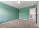Neutral carpeted bedroom featuring green walls and a door leading to the hallway at 1617 Post Ct, Gastonia, NC 28054