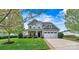 Charming two-story home boasts manicured lawn, stone accents, attached two-car garage, and inviting covered front porch at 1617 Post Ct, Gastonia, NC 28054