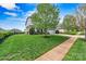 Landscaped front yard with healthy lawn and mature trees, leading up to this charming two-story house at 1617 Post Ct, Gastonia, NC 28054