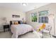 Bright and airy bedroom features a bed and two windows overlooking trees and foliage at 1620#F Arlyn Cir, Charlotte, NC 28213