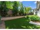 Lush backyard with artificial turf, manicured landscaping, and retaining wall, creating a private oasis at 17728 Jetton Green Loop, Cornelius, NC 28031
