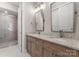Bathroom with a modern vanity with granite countertop and large framed mirror, plus tiled shower at 17728 Jetton Green Loop, Cornelius, NC 28031