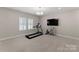 Spacious home gym includes treadmill, tv, and storage shelves perfect for exercise equipment at 17728 Jetton Green Loop, Cornelius, NC 28031