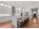 Modern kitchen with stainless steel appliances, pendant lighting, large island with seating, and hardwood floors at 17728 Jetton Green Loop, Cornelius, NC 28031