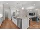 Open kitchen with stainless appliances, an island with seating, flows into a living room with built-in bookshelves at 17728 Jetton Green Loop, Cornelius, NC 28031