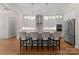 Modern kitchen with stainless steel appliances, pendant lighting, large island with seating, and hardwood floors at 17728 Jetton Green Loop, Cornelius, NC 28031