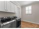 Well-equipped laundry room with modern appliances, white cabinets, and natural light from the window at 17728 Jetton Green Loop, Cornelius, NC 28031