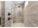 Tiled shower with gray, horizontal tiles, dual shower head and mosaic tile flooring at 17728 Jetton Green Loop, Cornelius, NC 28031