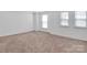 Bright bedroom featuring three windows and neutral carpet at 1834 Teachers House Nw Rd, Concord, NC 28027