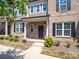 Charming brick townhome showcasing well-maintained landscaping and a welcoming front porch at 1834 Teachers House Nw Rd, Concord, NC 28027