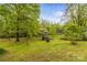 The backyard provides a serene retreat with a storage shed, mature trees, and a tranquil atmosphere amidst lush greenery at 2106 4Th Ne St, Hickory, NC 28601